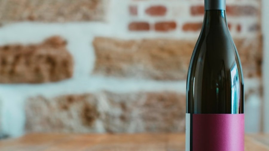 bottiglia di vino rosso in verticale con luce calda