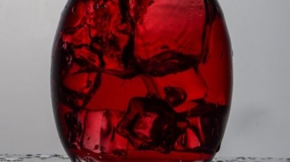 mano che agita eccessivamente il decanter con vino rosso