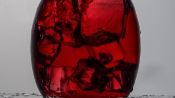 mano che agita eccessivamente il decanter con vino rosso