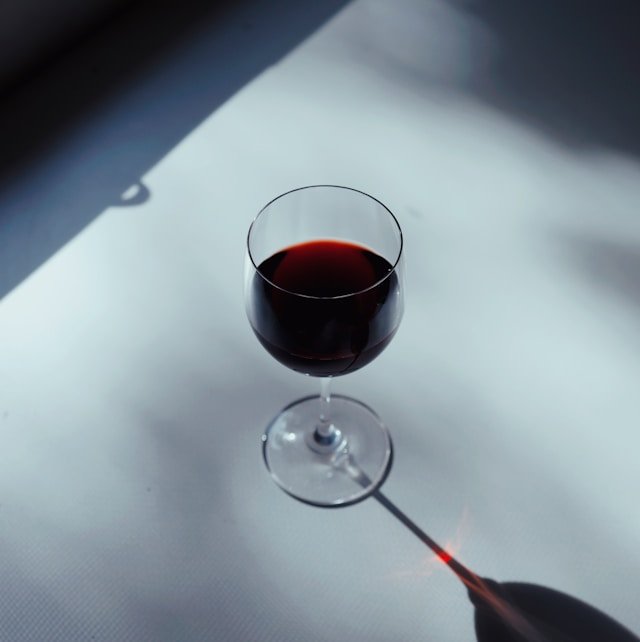 Calice di vino rosso illuminato per mostrare il corpo del vino
