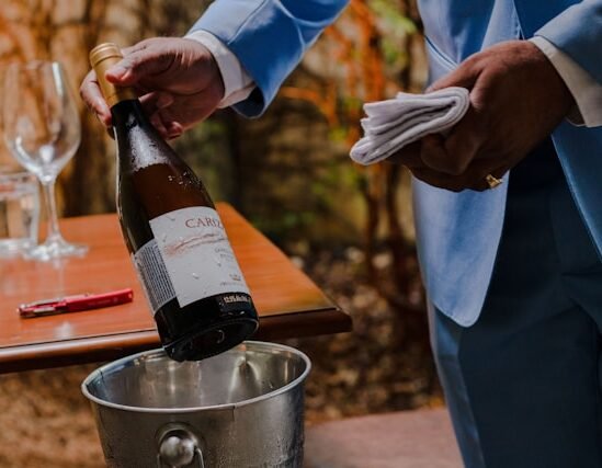 Mano che indica i dettagli di un’etichetta di vino in primo piano