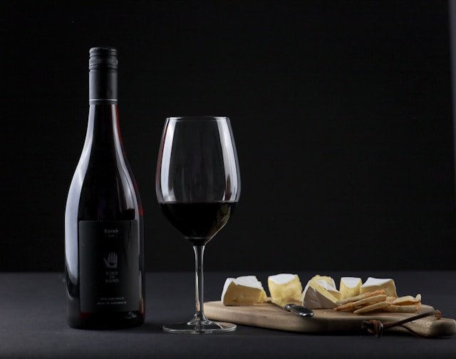 Bicchiere di vino rosso e tagliere di formaggi italiani