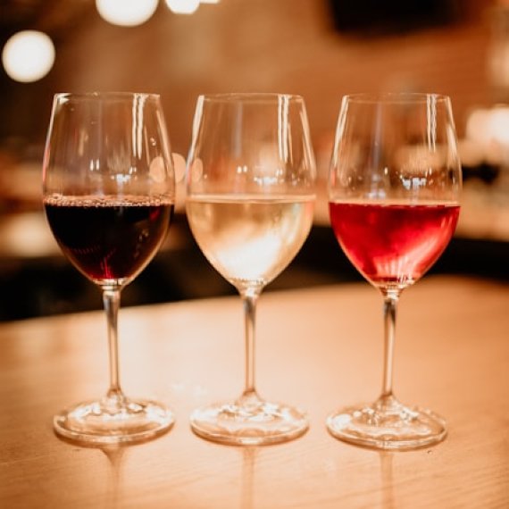 Bicchieri di vino rosso e bianco su tavolo in legno