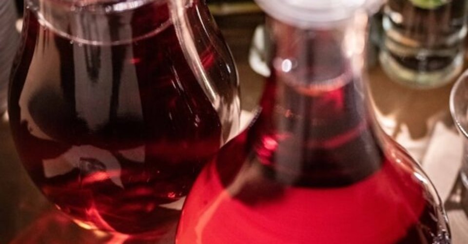 vino rosso versato in caraffa di vetro in cucina