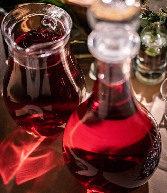 vino rosso versato in caraffa di vetro in cucina